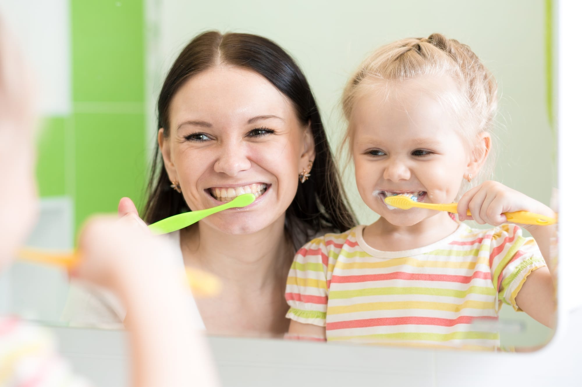 mom and daughter brushing teeth