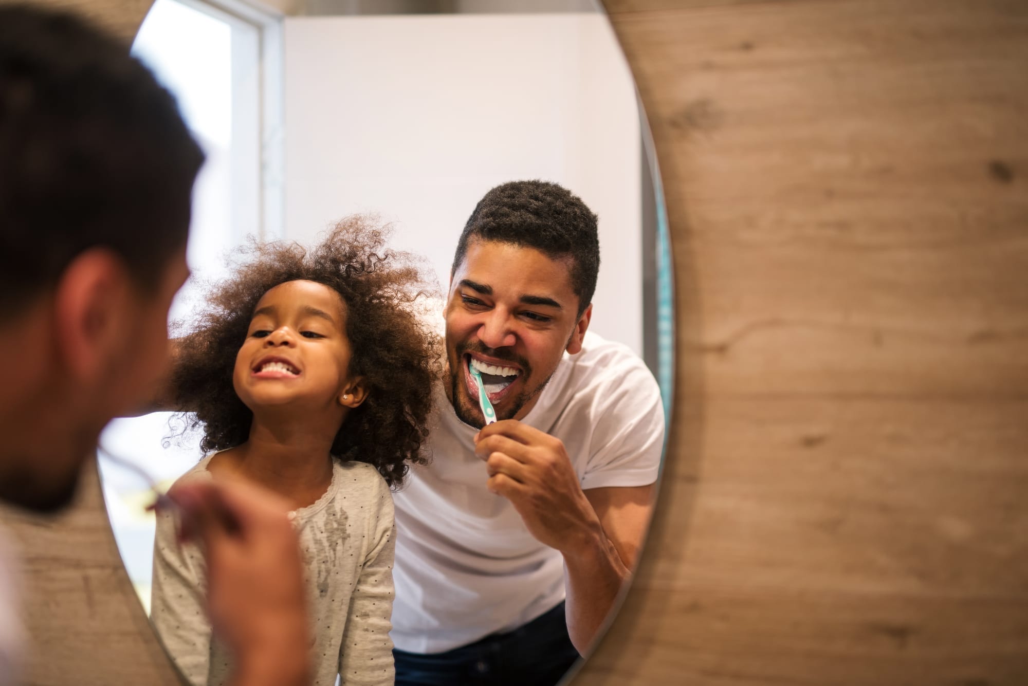 father and daughter brushing teeth