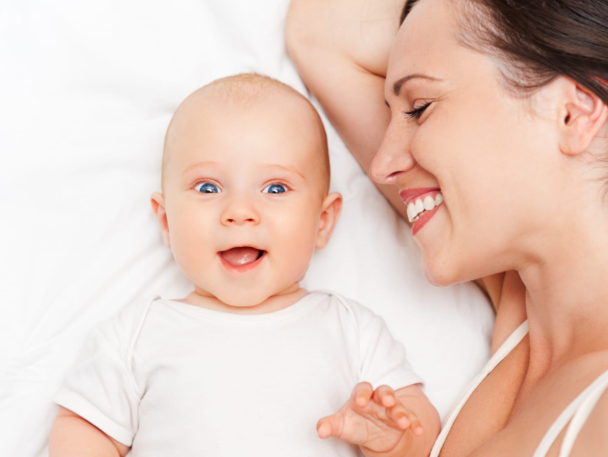 mother and baby lying on bed