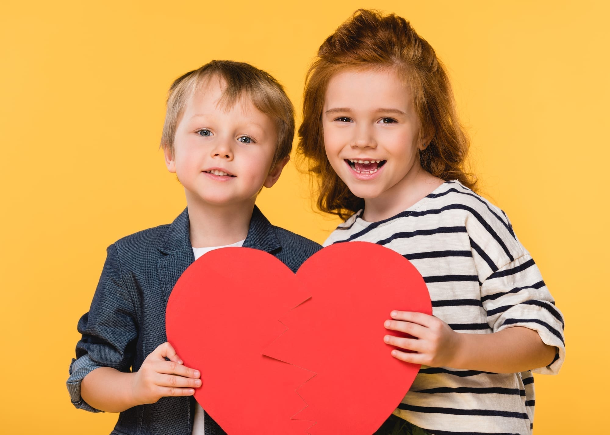 little girl and boy holding heart