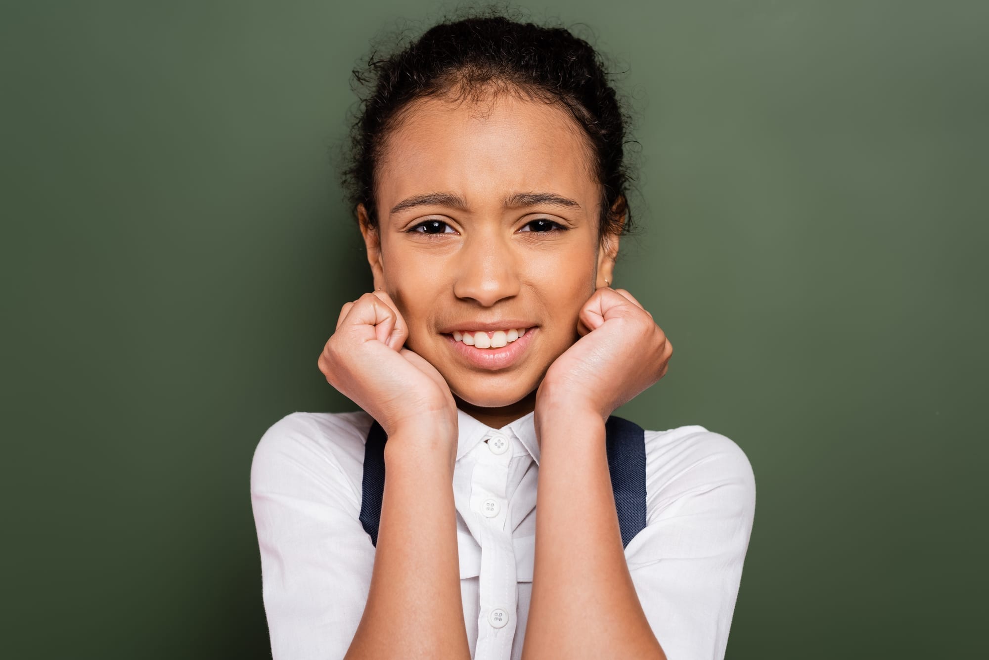 nervous young girl standing in front of green background