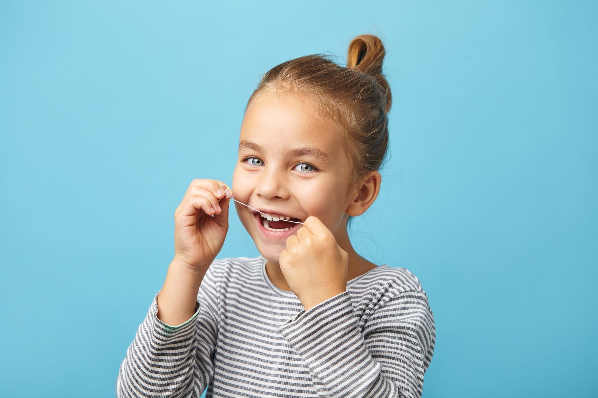 little girl flossing on blue background