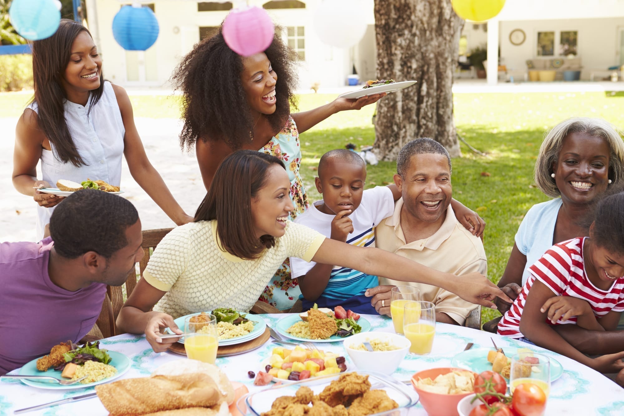 family laughing, eating, having part outside