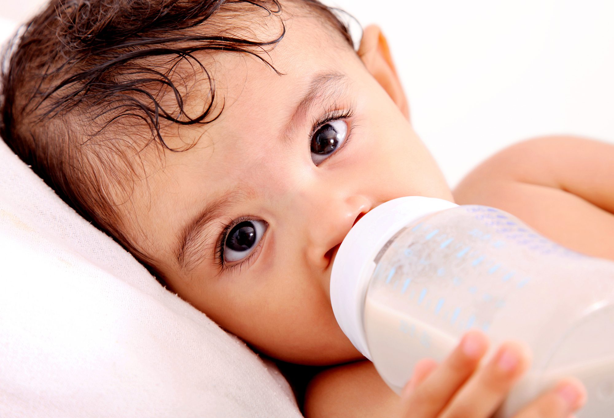 close up of toddler holding bottle