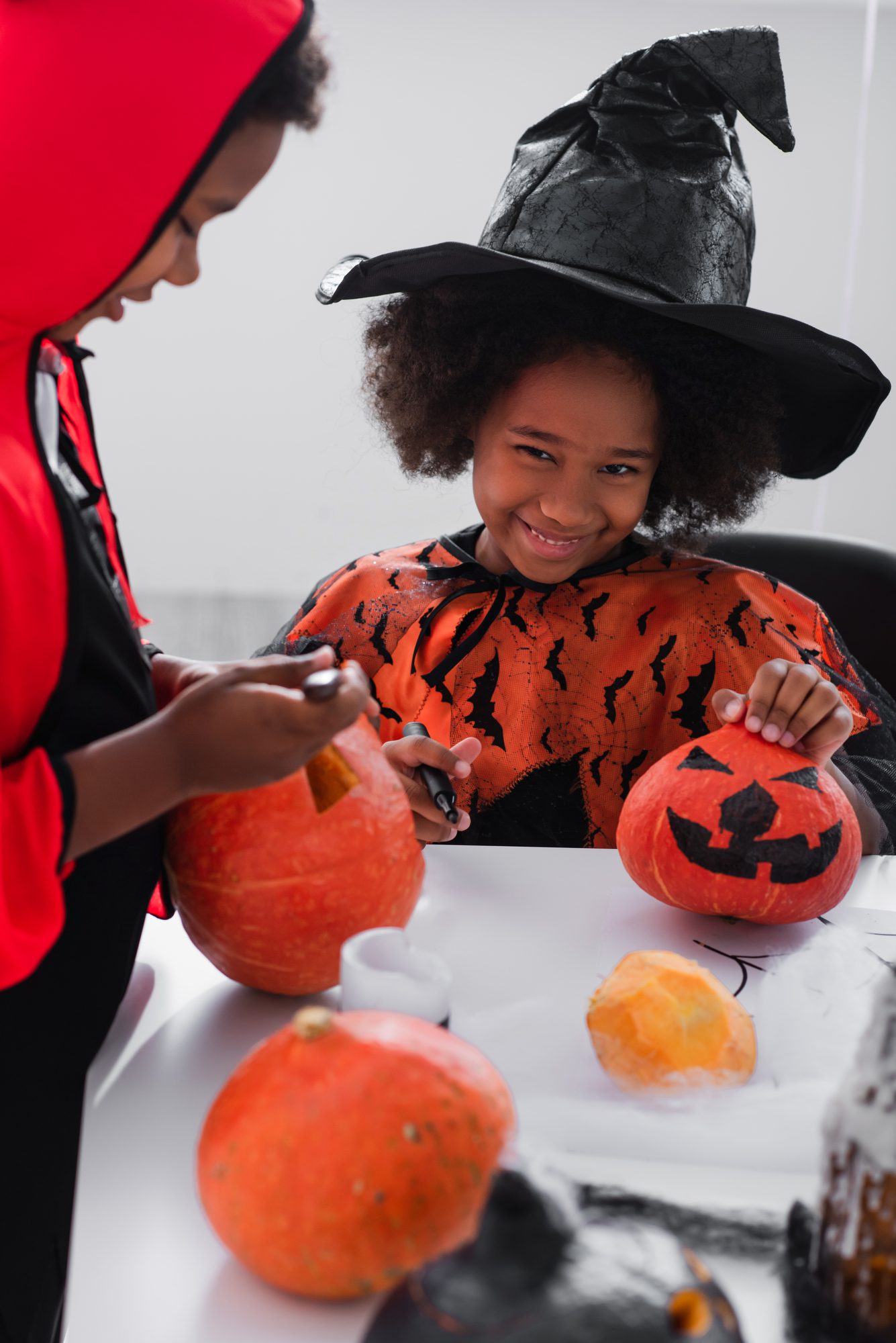 young boy and girl carving pumpkins which is a healthy snack