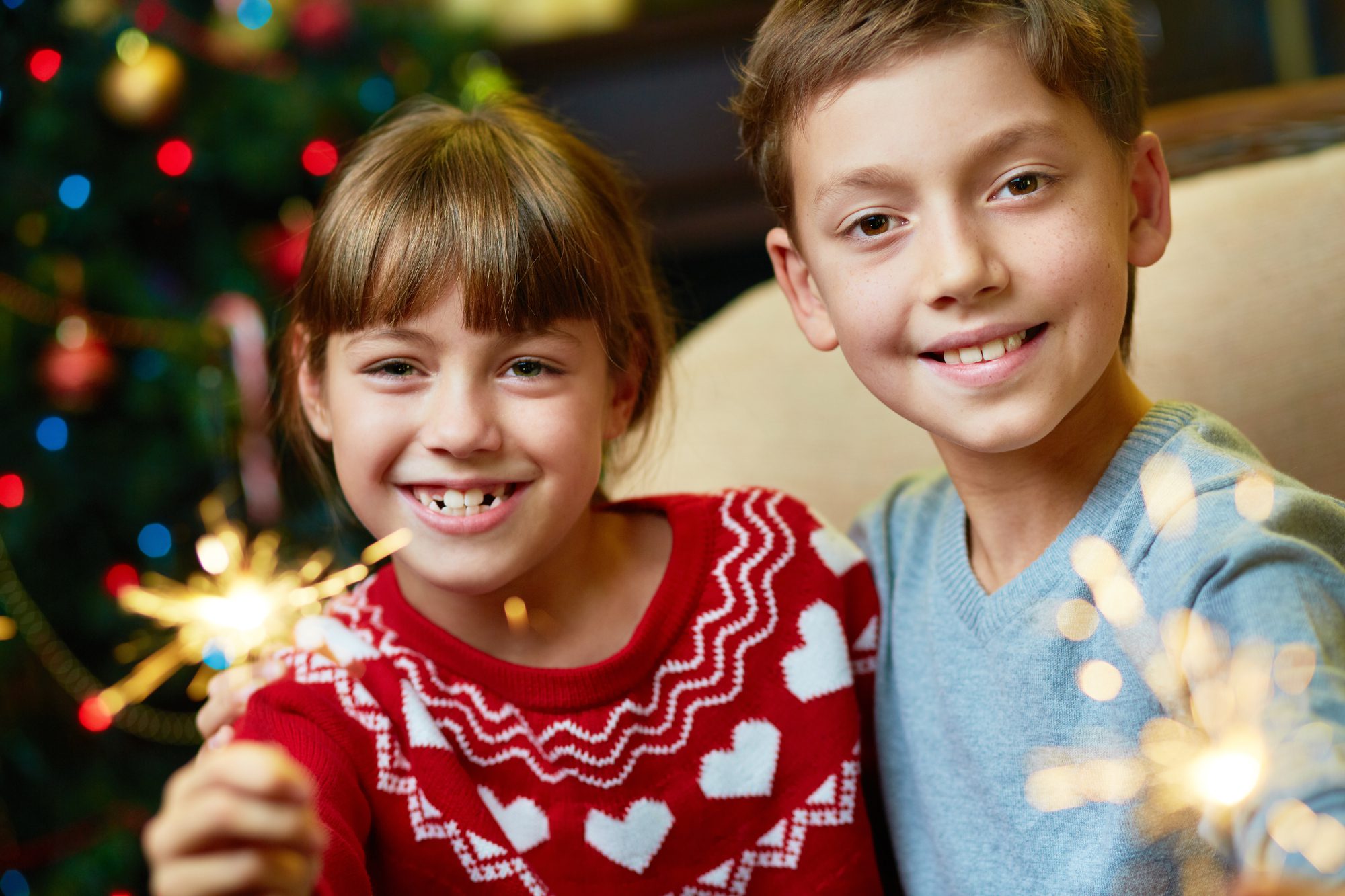 Boy and girl celebrating New Year's with fireworks