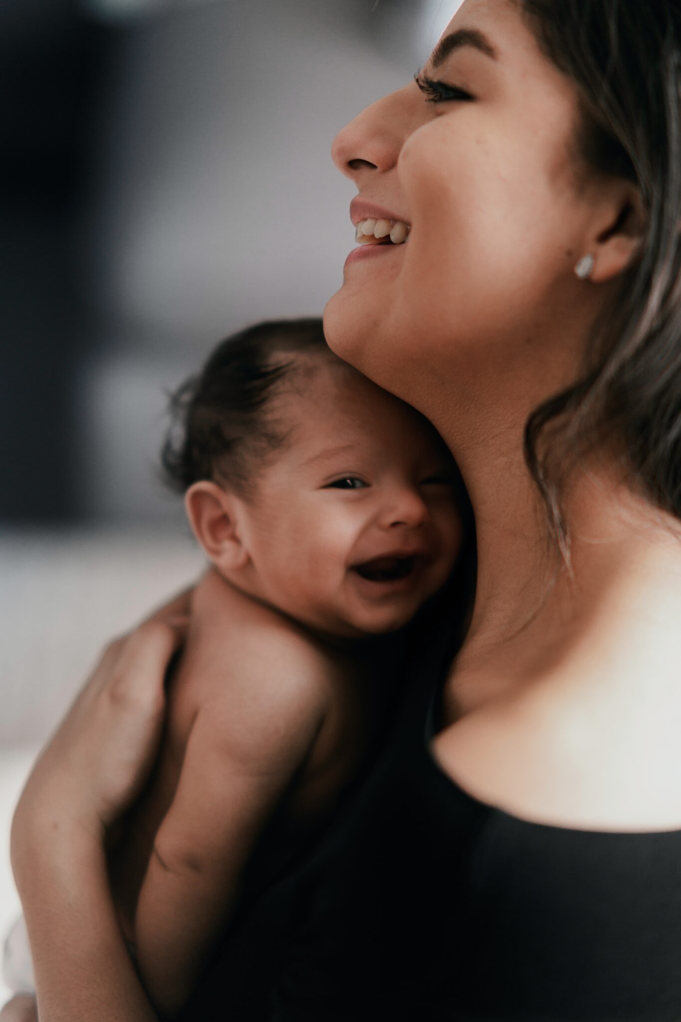 baby smiling while being held by mother