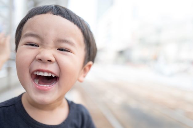 young boy smiling and celebrating Oral Health Month