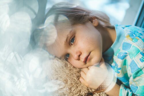 young child laying down and suffering from jaw pain