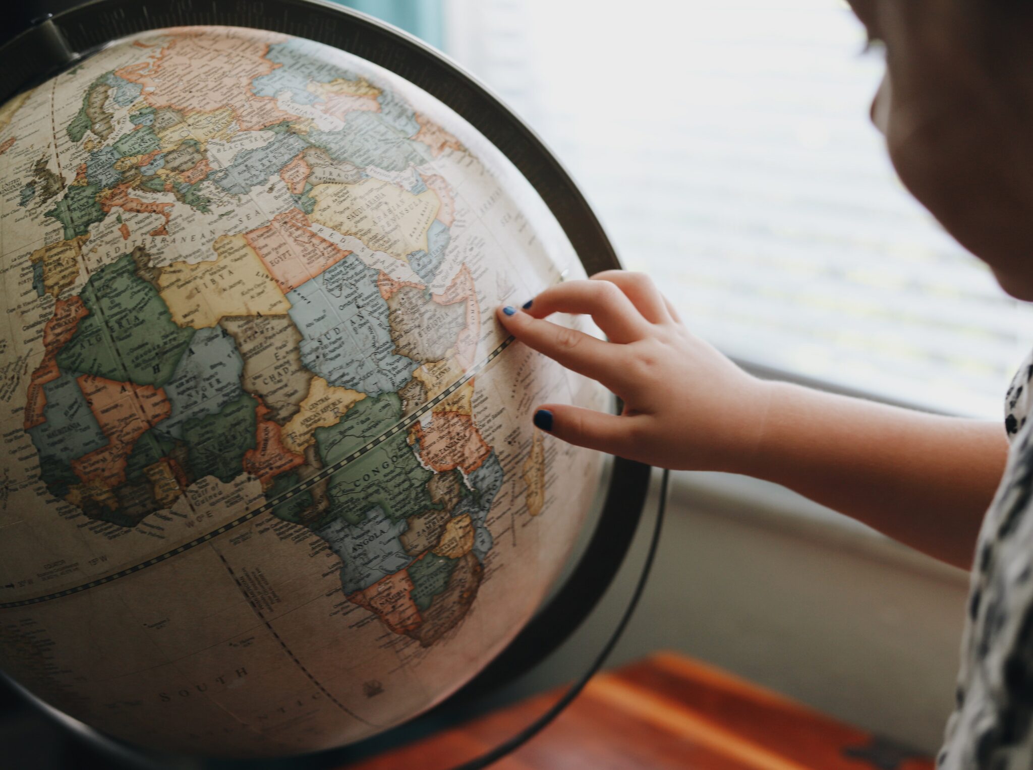 Child's finger on a globe