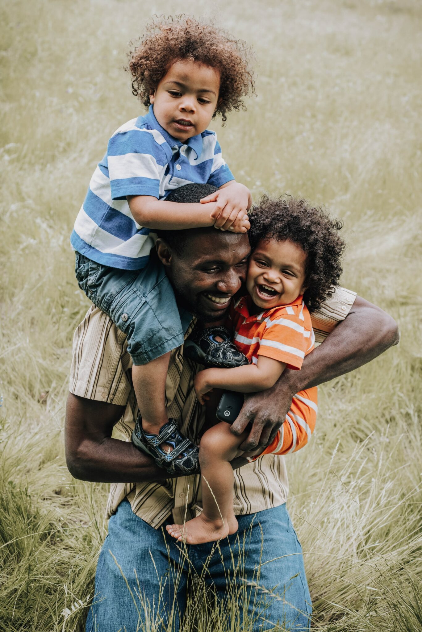 Dad plays with his children in a field