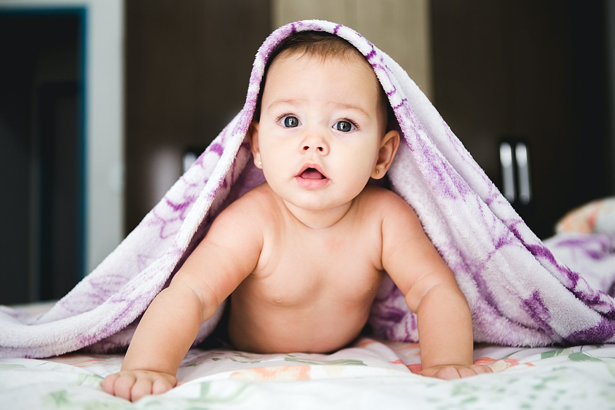 Baby under a purple blanket
